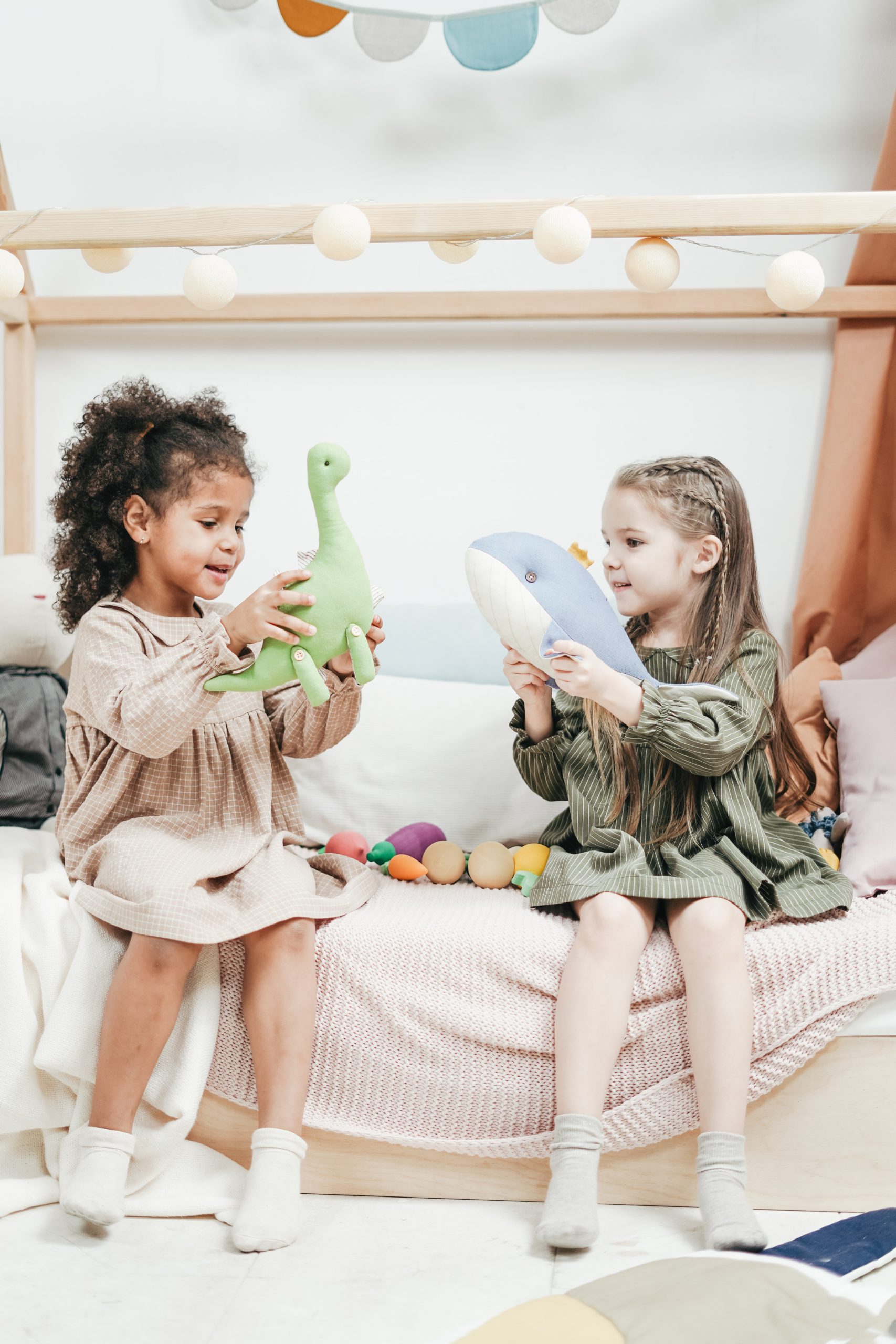 two girls playing with stuff animals