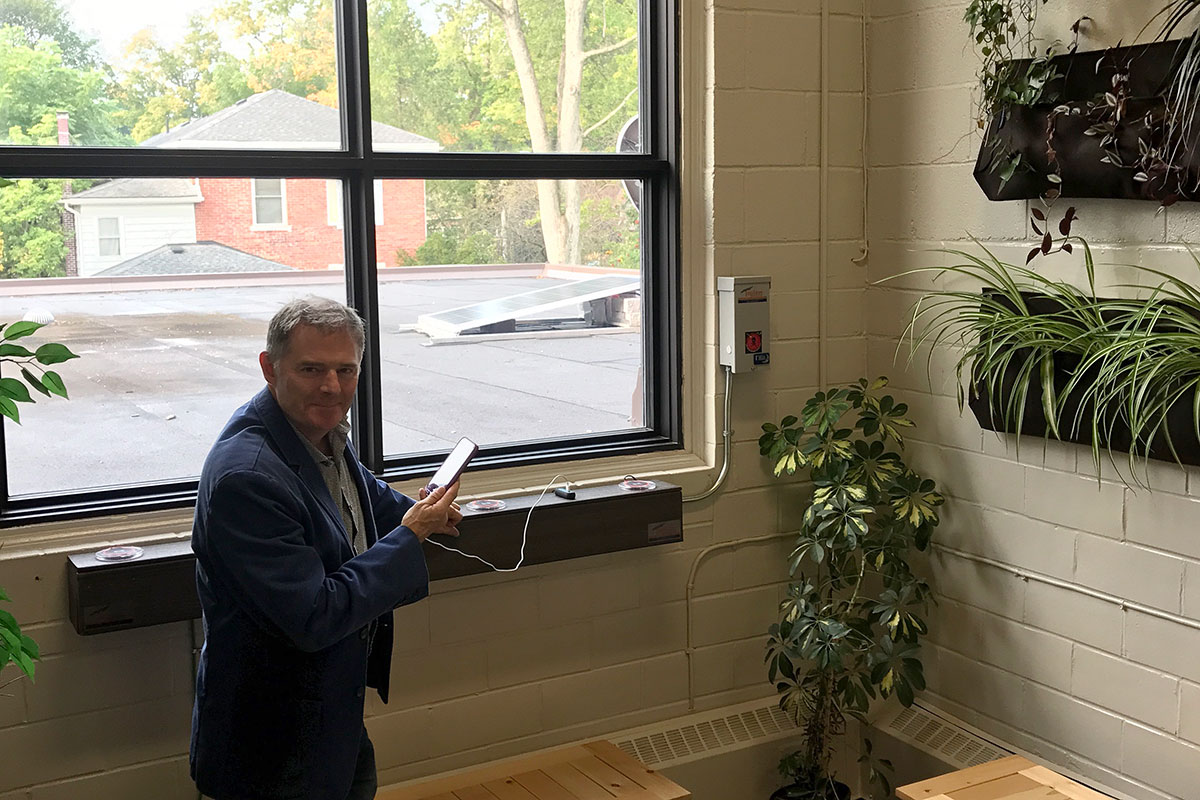 Norwell DSS Principal Paul Richard charges his phone at the school's solar panel charging station (September 2017).