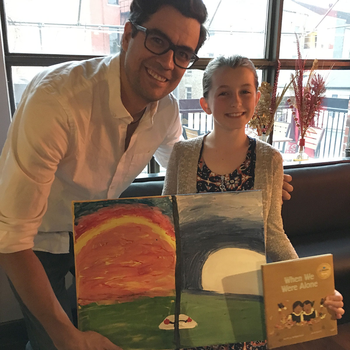 John Black PS student Eliina presents a painting to author David Robertson, May 14, 2018.
