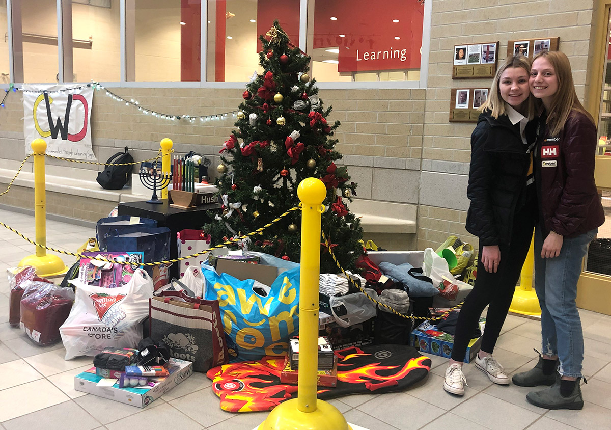 CWDHS students are pictured next to a Christmas tree and gifts they collected for members of the community (December 2019).