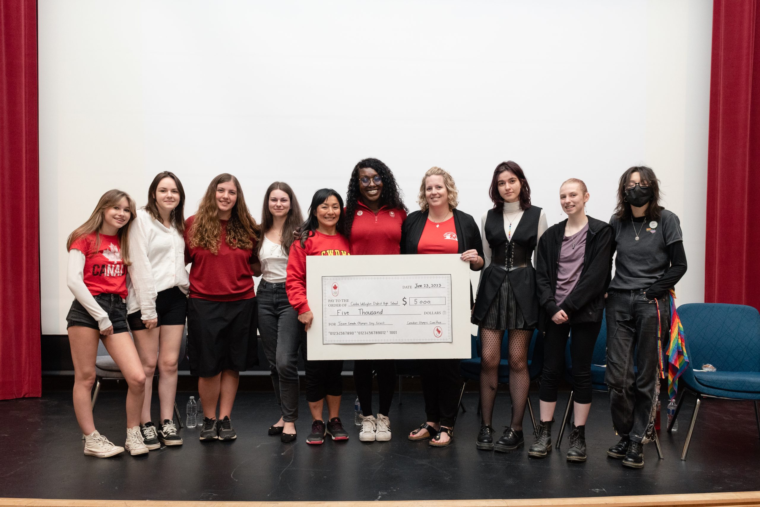 This photo features Cynthia Appiah and students posing with large grant cheque. 