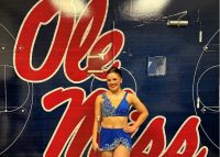 This photo features Elsie P. posing in front of a Ole Miss sign.